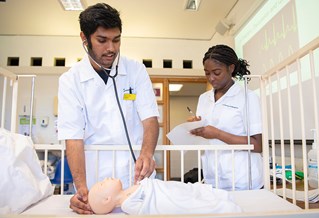 Two nursing students working together on baby dummy