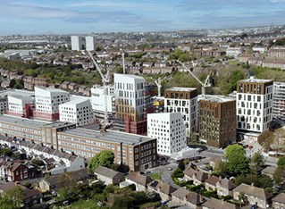 Aerial photo of Moulsecoomb campus showing high-rise buildings with cityscape towards the coast