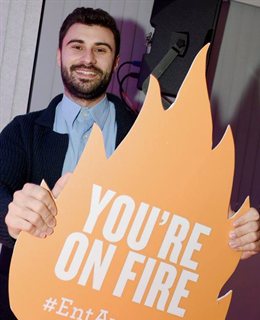 Oscar Blazquez Sanchez holding a board that says You're On Fire