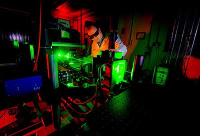 Male engineer researcher using lasers in the lab