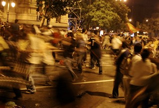 Crowd rioting in night city scene