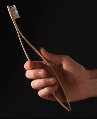 Hand gripping toothbrush designed with two flexible handles designed to be squeezed as help for rheumatoid arthritis sufferers