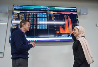 Lecturer and PG student looking at Bloomberg screen