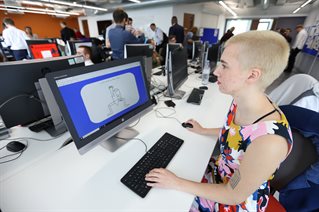 Female student in flowery dress working at a computer