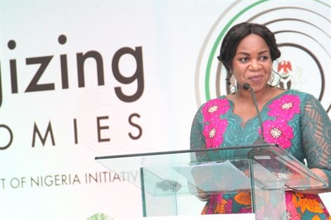 Damilola speaking at a conference with a microphone on a podium
