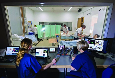 Student nurses being monitored through a window