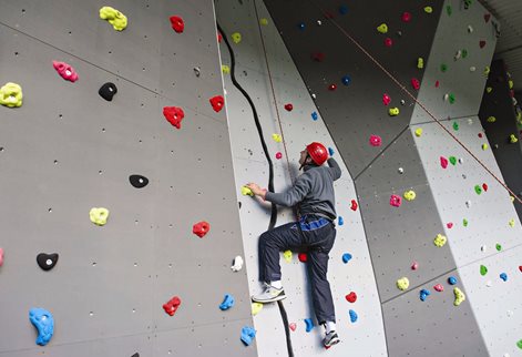 A student scaling the climbing wall