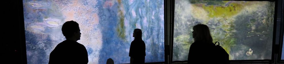 Silhouettes of people in front of abstract artwork on two screens