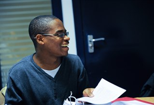 A student holding a folder and laughing