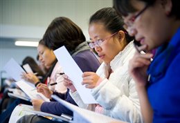Students reading notes in a seminar