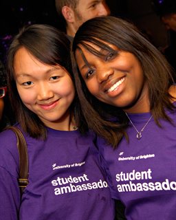 Two smiling students in purple 'student ambassador' t-shirts