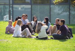 Students sitting in a ring on the grass