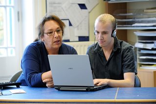 Two people looking at a laptop