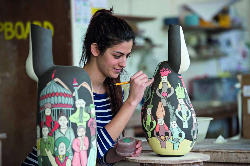 student painting a colourful pot