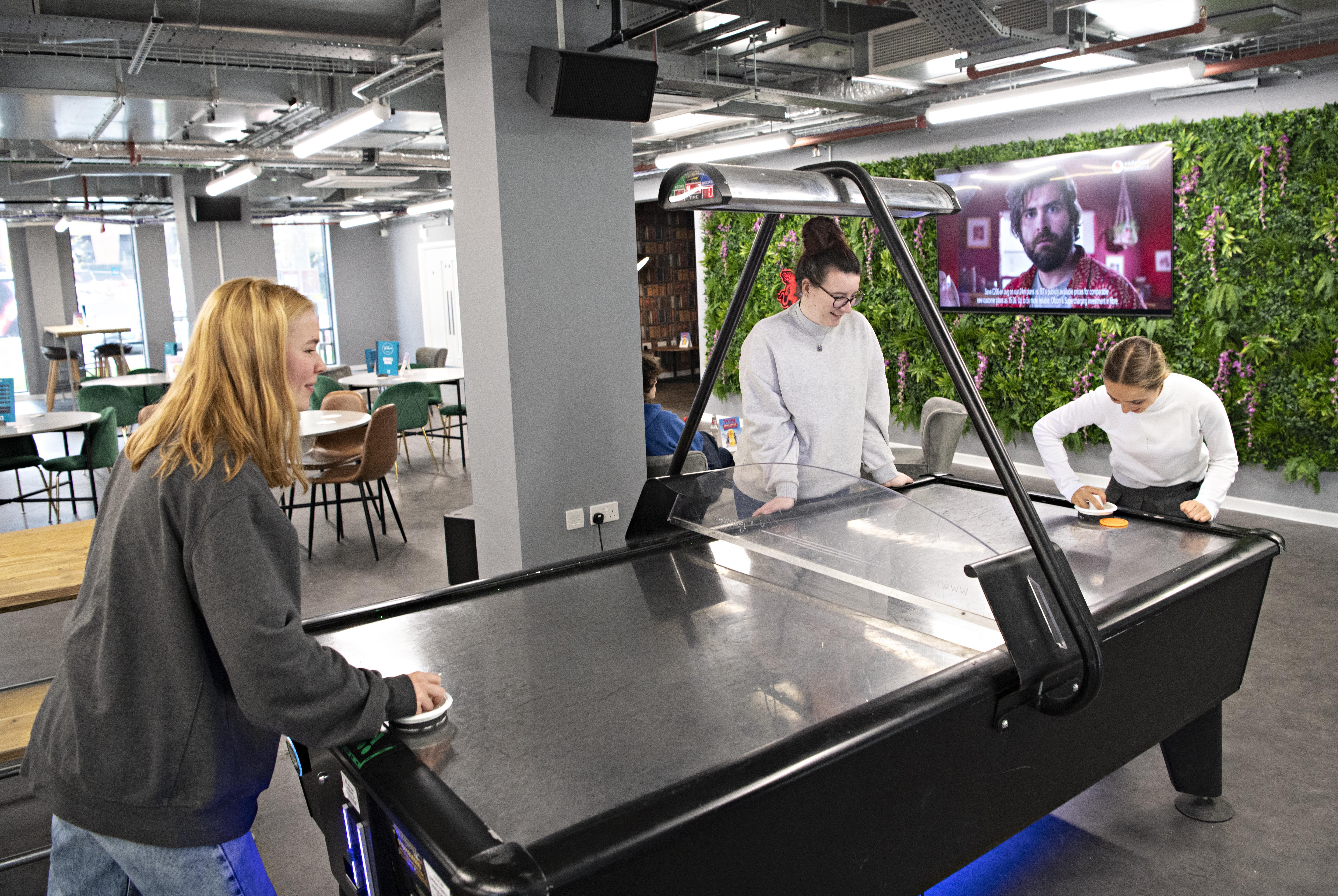 Two Students playing air hockey in the Students' Union bar