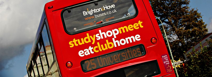 Rear end of bright red double decker bus with universities destination sign, Brighton and Hove logo and the legend study, shop , meet, eat, club, home