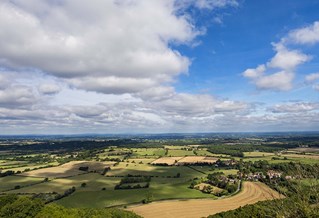 Aerial view of the South Downs, East Sussex, under bright sky with white cloud.