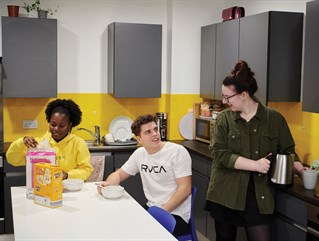 Three students in a kitchen