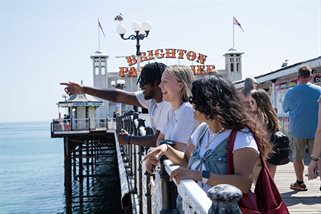 A group of students on Brighton Palace Pier on a sunny day
