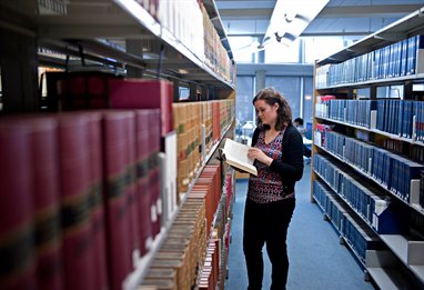 Business student looking at a book in the library