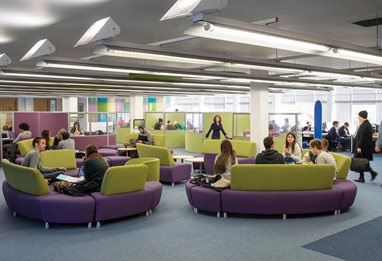 Students on comfy chairs in a student lounge