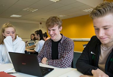 Three students around a computer