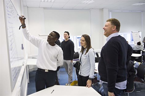 Students in a seminar using a whiteboard