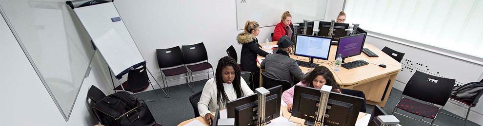 Business management students using computers in lecture