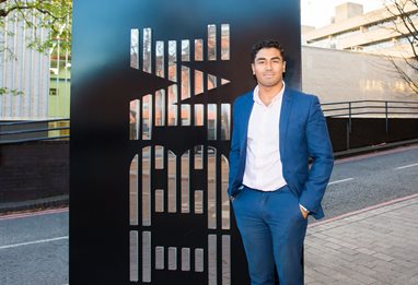 Man in a suit standing next to the IBM logo