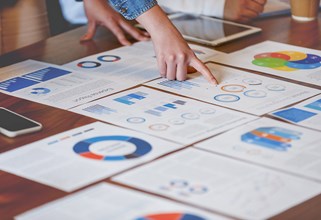 Finger pointing at charts on a table