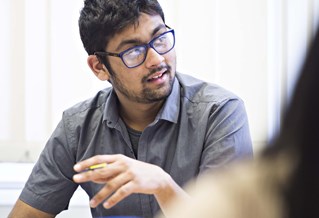 Postgraduate student posing questions during a seminar in the School of Business and Law