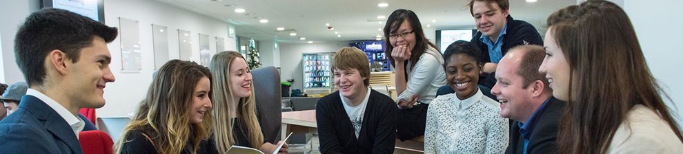 Students gather in an informal learning environment with teaching staff