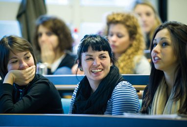 Students talking in the front of a lecture room