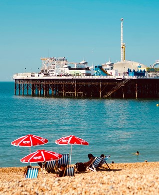 Brighton Pier with people on the beach in the heat