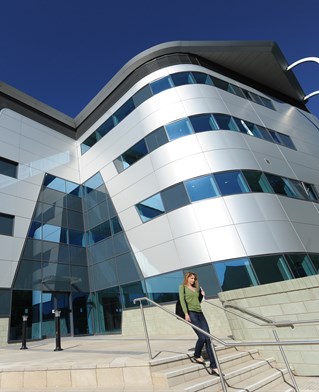 Silver grey front of Huxley Building, University of Brighton, with steps and metallic curves and straights.