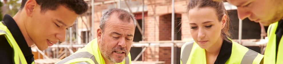 Apprentices looking at building plans