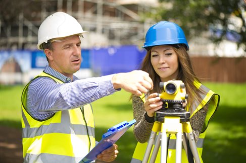 Men and woman in hardhat using level