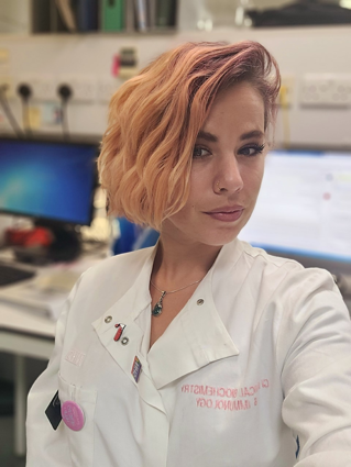 Meghann Creffield in a lab in a white lab coat