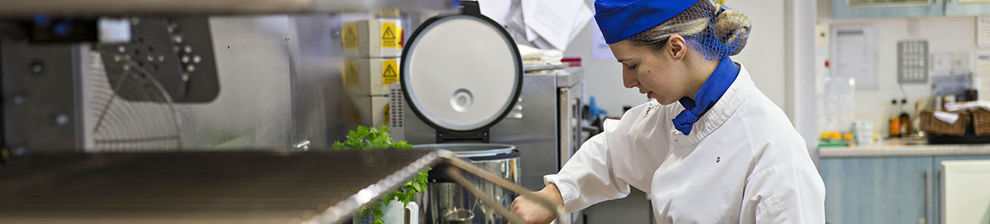 Hospitality student in chef's garments in kitchen