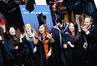 Students in robes throwing their hats in the air at graduation