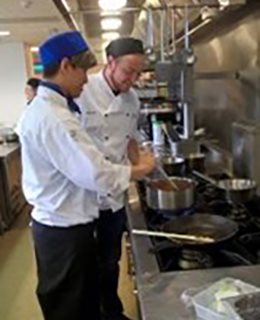  Two people cooking together in a large kitchen