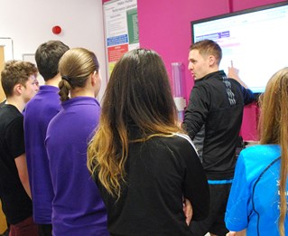 Students looking at a large screen on the wall