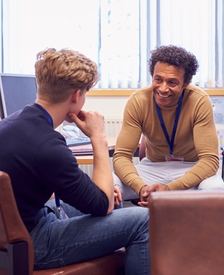 Student and mentor in discussion in university offices.