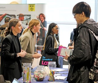 Careers fair with young people at stalls.