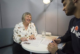 Careers adviser and student at a table with leaflets