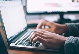 close up of hands typing on laptop keyboard