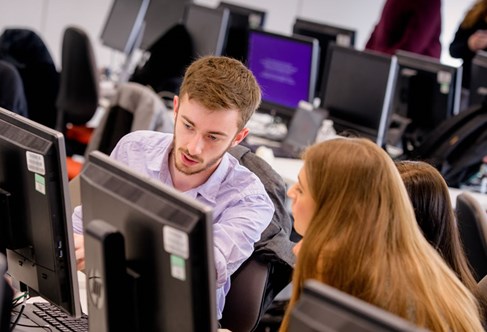 Students in computer places in university pool room