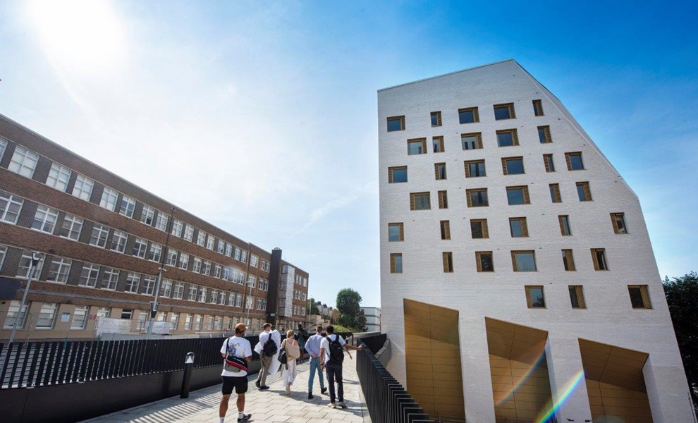 Students walking past modern halls of residence