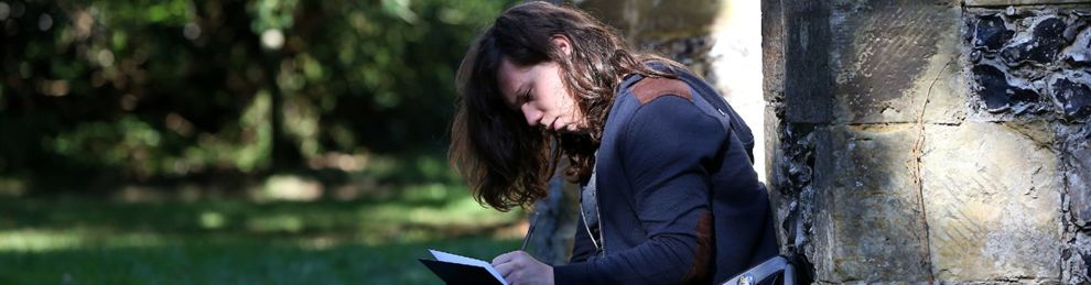 Student writing in park