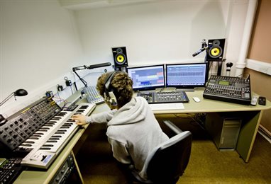 Student in headphones using the digital music and sound art facilities